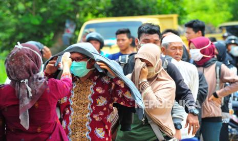 Petugas kesehatan mengecek suhu tubuh warga yang akan melakukan perjalanan dan memasuki Kota Jambi dari Kabupaten Muarojambi serta Tanjungjabung Barat, Jambi. Tiga orang warga Kota Jambi yang dilakukan rapid tes oleh gugus tugas COVID-19 Kota Jambi hasilnya positif terinfeksi virus.