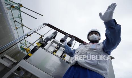 This photo taken during the tour of the treated water dilution and discharge facility for foreign media shows TEPCO official Kenichi Takahara explains about a facility to take samples of treated radioactive wastewater after dilution for testing before release, part of the facility for the releasing treated radioactive water to sea from the Fukushima Daiichi nuclear power plant, operated by Tokyo Electric Power Company Holdings (TEPCO), in Futaba town, northeastern Japan, Sunday, Aug. 27, 2023. 