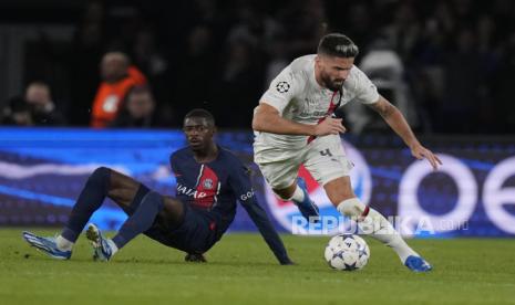 Olivier Giroud dari AC Milan (kanan) membawa bola melewati pemain PSG Ousmane Dembele pada pertandingan sepak bola grup F Liga Champions antara Paris Saint Germain dan AC Milan di stadion Parc des Princes di Paris, Kamis (26/10/2023)dini hari WIB.