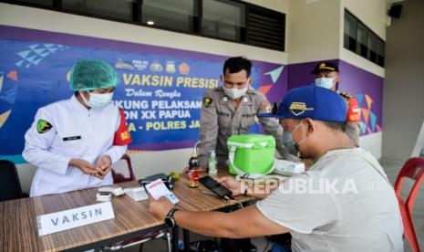 Warga menerima hasil vaksin saat akan memasuki arena pertandingan di Istora Papua Bangkit, Kompleks Kampung Harapan, Sentani, Kanupaten Jayapura, Papua, Kamis (7/10). Setelah terjadi kasus positif saat gelaran PON XX Papua, Sejumlah venue menerapkan protokol kesehatan yang ketat seperti pembatasan maksimal kapasitas arena dan penyediaan layanan vaksin dan swab antigen untuk penonton. Republika/Thoudy Badai