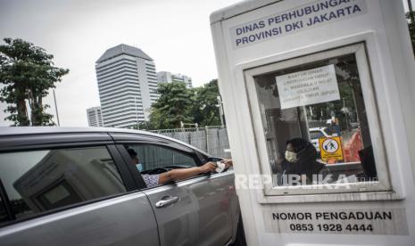 Pengendara mobil menyerahkan karcis parkir ke petugas di lapangan IRTI Monas, Jakarta Pusat, Jakarta, Rabu (23/6/2021). Pemerintah Provinsi DKI Jakarta berencana menaikkan tarif layanan parkir dengan tarif tertinggi Rp60 ribu per jam untuk mobil dan Rp18 ribu per jam untuk motor yang bertujuan mendorong warga Jakarta beralih menggunakan transportasi umum. 