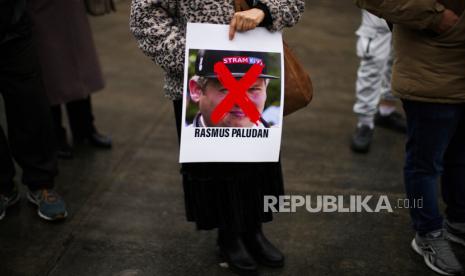  Swedia Imbau Warganya di Turki untuk Menghindari Keramaian. Foto: Seorang perempuan memegang foto aktivis sayap kanan Rasmus Paludan saat protes di luar konsulat Swedia di Istanbul, Turki, Sabtu, 28 Januari 2023. 