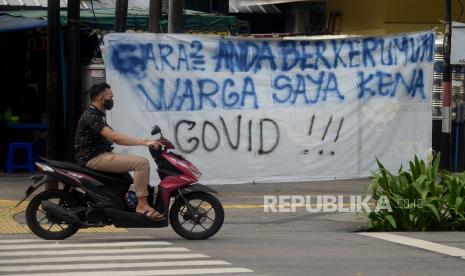 Warga melintas di dekat spanduk peringatan untuk warga yang berkerumun di kawasan Sabang, Jakarta, Ahad (23/5). Tren jumlah pasien rawat inap di RS Darurat COVID-19 Wisma Atlet Kemayoran terus bertambah dalam lima hari terakhir. Penambahan itu seiring dengan banyaknya jumlah pemudik yang terpapar Covid-19 pada arus balik Lebaran. Berdasarkan data Penerangan Komando Gabungan Wilayah Pertahanan (Kogabwilhan), jumlah pasien rawat inap di Wisma Atlet per Ahad (23/5) sebanyak 1.251 orang. Tren penambahan jumlah pasien di Wisma Atlet sudah terlihat sejak Rabu (19/5) di mana saat itu jumlah pasien yang dirawat sebanyak 931 orang.Prayogi/Republika.