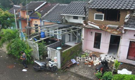 Seorang warga melintas di depan rumah yang rusak akibat gempa di Majangtengah, Malang, Jawa Timur, Ahad (11/4/2021). 