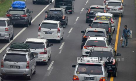 Pedagang menjajakan dagangannya kepada pemudik yang terjebak macet di KM 73 ruas Tol Cikopo-Palimanan, Purwakarta, Jawa Barat, Sabtu (30/4/2022). Meski telah dilarang, Sejumlah pedagang tetap berjualan di ruas tol untuk mengais rejeki dari para pemudik.Prayogi/Republika.