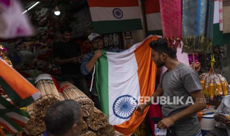 Seorang penjaga toko mengangkat bendera nasional untuk dijual menjelang Hari Kemerdekaan India. (ilustrasi)