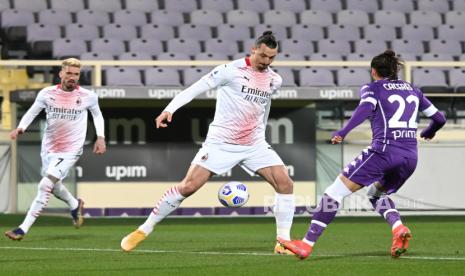 Penyerang Milan Zlatan Ibrahimovic (tengah) bersaing memperebutkan bola dengan bek Fiorentina Martin Caceres (kanan) pada pertandingan sepak bola Serie A Italia antara ACF Fiorentina dan AC Milan di stadion Artemio Franchi di Florence, Italia, Senin (22/3) dini hari WIB. 