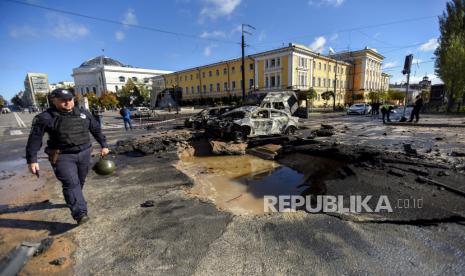  Seorang petugas polisi (kiri) berjalan melewati mobil yang hancur di jalan yang rusak setelah penembakan di pusat kota Kyiv (Kiev), Ukraina, 10 Oktober 2022. Ledakan telah dilaporkan di beberapa distrik di ibukota Ukraina Kyiv pada 10 Oktober, dengan penyelamat memadamkan api dan membantu para korban di antara penduduk sipil, kata Layanan Darurat Negara (SES) Ukraina. Pasukan Rusia memasuki Ukraina pada 24 Februari 2022 memulai konflik yang telah memicu kehancuran dan krisis kemanusiaan.