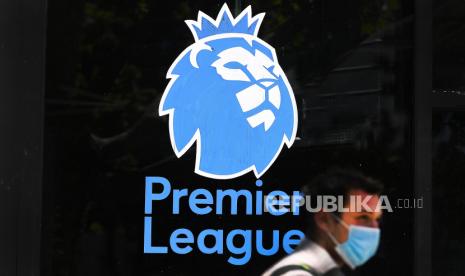  (FILE) - Seorang pria yang mengenakan masker pelindung berjalan melewati logo Liga Primer Inggris di London, Inggris, 29 Mei 2020 (diterbitkan ulang pada 14 Desember 2021). Liga Primer Inggris pada 14 Desember 2021 melaporkan bahwa 42 pemain dan staf klub telah dinyatakan positif mengidap Covid-19.