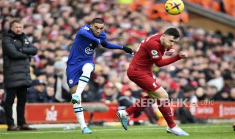 Hakim Ziyech menendang bola yang coba di blok Andrew Robertson (kanan) pada pertandingan sepak bola Liga Utama Inggris antara Liverpool FC dan Chelsea FC di Liverpool, Inggris, Sabtu (21/1/2023).