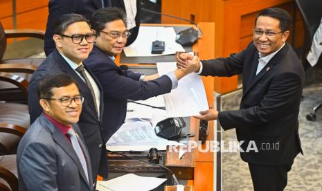 Menteri Hukum Supratman Andi Agtas (kanan) berjabat tangan dengan Ketua Komisi I DPR RI Utut Adianto (kedua kanan) disaksikan oleh Wakil Ketua Komisi I DPR RI Dave Laksono (kedua kiri) dan Ahmad Heryawan (kiri) saat rapat persetujuan tingkat I RUU TNI di Kompleks Parlemen, Senayan, Jakarta, Selasa (18/3/2025).  Komisi I DPR menyetujui pembahasan Rancangan Undang-Undang (RUU) tentang Perubahan atas Undang-Undang Nomor 34 Tahun 2004 tentang Tentara Nasional Indonesia (TNI) pada tingkat I, untuk dibawa ke tingkat selanjutnya di Rapat Paripurna DPR. 