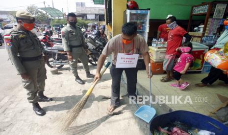 Pelanggar PSBB pra Adaptasi Kebiasaan Baru (AKB) membersihkan ruang publik di kawasan Pasar Cibinong, Kabupaten Bogor, Jawa Barat, Rabu (29/7/2020). Pemerintah Kabupaten Bogor menerapkan sanksi denda sebesar Rp50 ribu serta sanksi sosial yakni kewajiban membersihkan area publik bagi warga yang tidak menggunakan masker di tempat umum. 