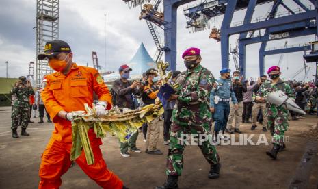 Petugas gabungan membawa bagian pesawat Sriwijaya Air SJ182 rute Jakarta - Pontianak yang jatuh di perairan Pulau Seribu di Dermaga JICT, Tanjung Priok, Jakarta Utara, Minggu (10/1/2021). Temuan bagian pesawat selanjutnya akan diperiksa oleh Komite Nasional Keselamatan Transportasi (KNKT) sedangkan potongan tubuh korban diserahkan kepada DVI Polri untuk identifikasi lebih lanjut. 