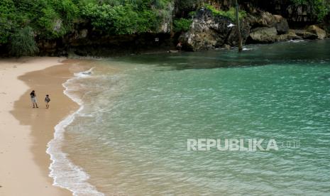 Wisatawan menikmati pasir putih di Pantai Gesing, Panggang, Gunungkidul, Yogyakarta.