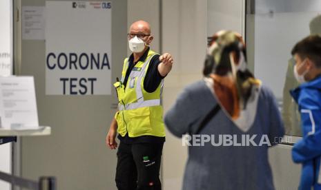 Eropa Umumkan Strategi Hadapi Covid-19 di Musim Liburan. Seorang penjaga menunjuk ke penumpang yang tiba untuk tes COVID-19 di pusat pengujian baru di bandara di Duesseldorf, Jerman, Senin, 27 Juli 2020. Pusat pengujian baru untuk virus corona didirikan di bandara Jerman karena pandemi, uji korona gratis diberikan untuk mereka yang kembali dari negara-negara yang ditunjuk sebagai daerah berisiko.