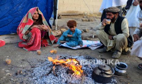 Warga Afghanistan menghangatkan diri di sekitar api di luar rumah mereka yang hancur setelah gempa bumi di desa Gayan di provinsi Paktia, Afghanistan, 23 Juni 2022. Lebih dari 1.000 orang tewas dan lebih dari 1.500 lainnya terluka setelah gempa berkekuatan 5,9 melanda Afghanistan timur sebelum fajar pada 22 Juni , Kantor Berita Bakhtar yang dikelola pemerintah Afghanistan melaporkan. Gempa itu adalah yang paling mematikan di Afghanistan dalam dua dekade dan para pejabat mengatakan jumlah korban tewas bisa meningkat.