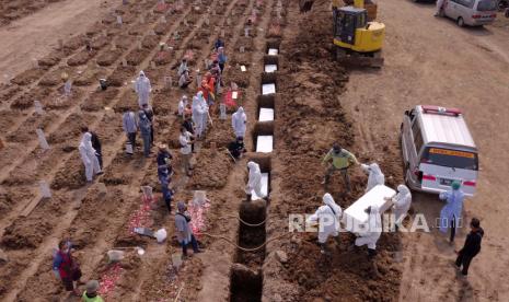 Foto udara yang diambil dengan drone menunjukkan pekerja yang mengenakan APD membawa peti mati orang yang meninggal dengan COVID-19, selama pemakaman di pemakaman yang didedikasikan untuk korban COVID-19 di Jakarta, Indonesia, 7 Juli 2021.