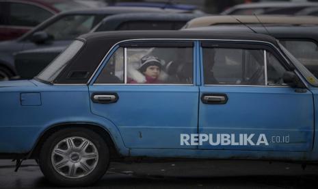 Seorang anak duduk di dalam mobil di luar stasiun kereta api, di Kyiv, Ukraina, Kamis, 3 Maret 2022. 