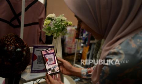 Seorang karyawan bertransaksi menggunakan QRIS (ilustrasi). Bank Indonesia (BI) mengedukasi Quick Response Code Indonesian Standard (QRIS) dan cinta Rupiah kepada tokoh agama, di Kota Manado, Provinsi Sulawesi Utara (Sulut).