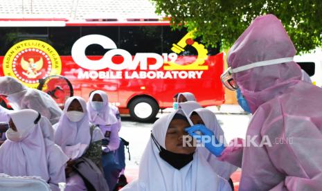 Petugas kesehatan melakukan tes usap Antigen pada pelajar sebelum mendapatkan suntikan vaksin COVID-19 saat kegiatan vaksinasi massal untuk pelajar yang ditinjau Presiden Joko Widodo di SMPN 3 Mejayan Kabupaten Madiun, Jawa Timur, Kamis (19/8/2021). Kegiatan vaksinasi massal tersebut menyediakan 2.500 dosis vaksin COVID-19 untuk pelajar SMP, SMA, SMK dan pondok pesantren. 