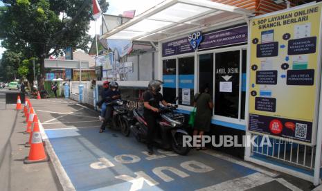 Sejumlah warga antre untuk mengambil KTP Elektronik melalui layanan tanpa turun (drive thru) di Disdukcapil Kota Bogor, Jawa Barat, Selasa (11/1/2022). Kementerian Dalam Negeri akan melakukan penerapan KTP Elektronik dalam bentuk digital yang memiliki kode batang (QR Code) secara bertahap dan mulai diuji coba di 58 kabupaten/kota. 