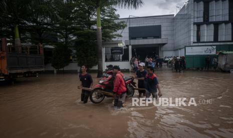 Sejumlah warga mengevakuasi motor saat banjir.