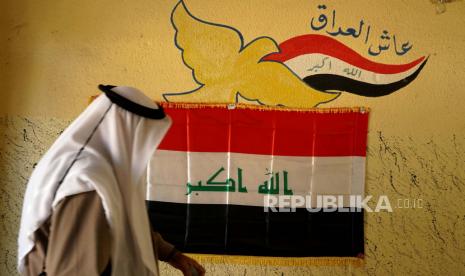  Seorang pria mengenakan pakaian tradisional Irak tiba untuk memberikan suara selama pemilihan parlemen, di sebuah tempat pemungutan suara di Mosul, Irak, Ahad, 10 Oktober 2021. Prancis akan buka misi diplomatik di Kota Mosul, Irak.