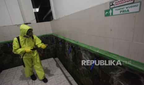 Anggota Tim Emergency Response Palangkaraya (ERP) melakukan penyemprotan cairan disinfektan di tempat wudhu Masjid Darul Qudsi, Palangkaraya, Kalimantan Tengah, Rabu (18/3/2020) malam. (ANTARA/Makna Zaezar)