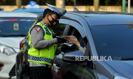 Petugas Kepolisian melakukan penindakan tilang manual terhadap pengemudi di kawasan Bundaran Hotel Indonesia, Jakarta, Selasa (16/5/2023). Polri kembali memberlakukan tilang manual terhadap pengemudi yang melanggar lalu lintas. Kebijakan tersebut kembali diberlakukan lantaran pelanggaran lalu lintas meningkat di wilayah yang tidak terjangkau ETLE. Meski demikian, tilang elektroni akan tetap dioperasionalkan.