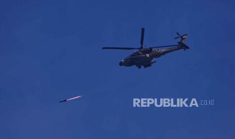 Helikopter Apache Israel menembakkan rudal ke arah Jalur Gaza, terlihat dari Israel selatan, Rabu, 6 Desember 2023.