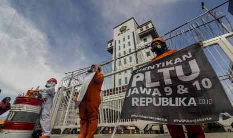 Aktivis Walhi menggelar aksi di depan gedung Kementerian ESDM, Jakarta, Jumat (11/12). Pada aksi tersebut mereka menuntut pemerintah untuk menghentikan pembangunan PLTU Batubara Jawa 9 dan 10 serta beralih ke energi baru terbarukan karena dinilai dapat merusak lingkungan. Republika/Putra M. Akbar