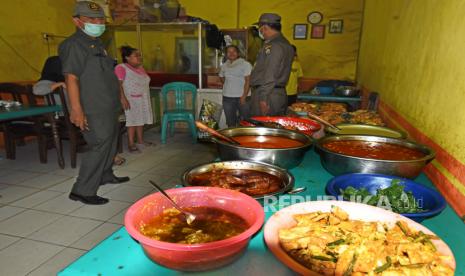 Anggota Satpol PP memberi peringatan kepada pengelola rumah makan yang tetap buka pada siang hari saat razia penegakkan Perda Bulan Ramadhan di Serang, Banten, Senin (11/5/2020). Pemkot Serang mengeluarkan Perda larangan berjualan bagi restoran dan warung makan di siang hari yang dikuatkan oleh MUI serta Kementerian Agama selama bulan Ramadhan untuk menghormati orang berpuasa