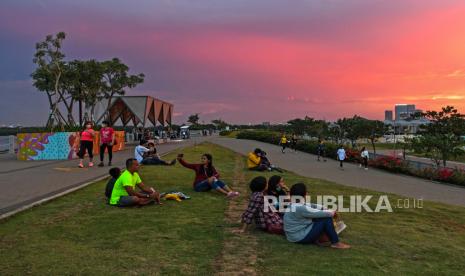 Warga menyaksikan matahari tenggelam saat mengunjungi kawasan Pantai Maju, Pantai Indah Kapuk (PIK), Kamal Muara, Jakarta, Sabtu (11/12/2021). Pantai Maju yang mempunyai fasilitas jalur jalan sehat dan sepeda santai (Jalasena) tersebut menjadi salah satu tujuan wisata di Ibu Kota. 