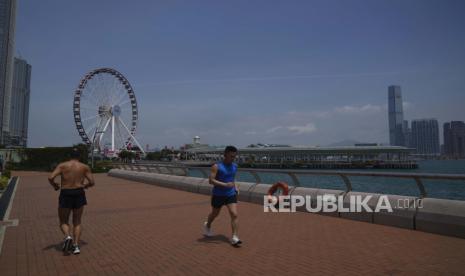  Orang-orang berlarian di tepi pantai di Hong Kong, Kamis, 5 Mei 2022. Kebakaran di pusat keuangan global Hong Kong telah menyebabkan 20.000 rumah tangga tanpa listrik selama dua hari di tengah cuaca panas dan lembab.