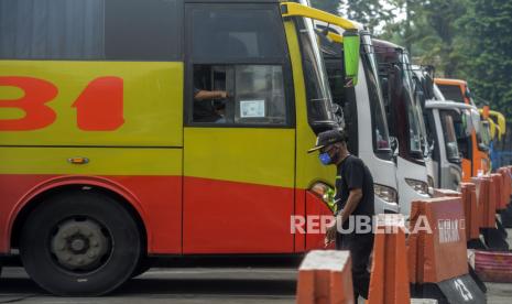 Sejumlah bus antar kota antar provinsi (AKAP) menunggu penumpang di Terminal Kampung Rambutan, Jakarta, Jumat (10/4). Pemerintah Provinsi (Pemprov) DKI Jakarta akan memperketat akses masuk ke Jakarta sebagai bentuk evaluasi penerapan Pembatasan Sosial Skala Besar (PSBB), setelah tiga hari penerapan yang dianggap masih belum maksimal. 