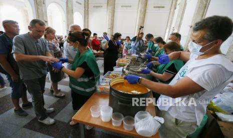 Pengungsi dari Mykolayiv menerima bantuan makanan kemanusiaan saat mereka menunggu di stasiun kereta api di Odesa, Ukraina barat daya, 02 Juni 2022, sebelum melakukan perjalanan ke barat Ukraina atau negara lain. Pihak berwenang Mykolayiv meminta penduduk setempat untuk meninggalkan beberapa wilayah kota di tengah invasi Rusia. 