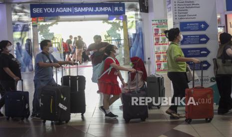 Sejumlah penumpang berjalan di area Pelabuhan Internasional Batam Centre, Batam, Kepulauan Riau, Selasa (27/12/2022). 