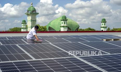 Petugas membersihkan permukaan panel surya yang terpasang di Pasar Gedhe, Klaten, Jawa Tengah, Rabu (6/12/2023). 