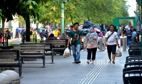 Wisatawan berjalan-jalan tanpa menggunakan masker di kawasan wisata Malioboro, Yogyakarta, Rabu (18/5/2022). Beberapa wisatawan mulai tidak menggunakan masker saat berwisata usai adanya pelonggaran aturan pemakaian masker di tengah Pandemi Covid-19 oleh Presiden Joko Widodo.