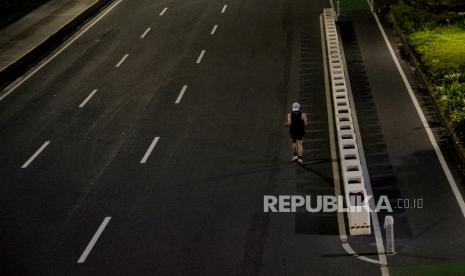 Warga berolahraga saat suasana lengang di jalan Sudirman-Thamrin, Jakarta, Rabu (12/5). Ditlantas Polda Metro Jaya melakukan penutupan Jalan Sudirman-Thamrin saat pelaksanaan crowd free night pada pukul 22.00 WIB dalam rangka mendukung pencegahan kerumunan di malam takbir Hari Raya Idul Fitri 1442 H. 