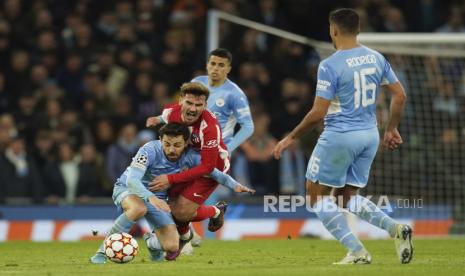 Pemain Manchester City Bernardo Silva, kiri, berebut bola dengan pemain Atletico Madrid Antoine Griezmann pada pertandingan leg pertama perempat final Liga Champions antara Manchester City dan Atletico Madrid di Stadion Etihad, di Manchester, Selasa, 5 April 2022.