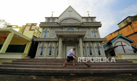 Umat Kristiani membersihkan halaman Gereja Pantekosta di Indonesia yang berdampingan dengan rumah warga Tionghoa di Sungai Nibung, Tungkal Ilir, Tanjungjabung Barat, Jambi, Jumat (29/1/2021). Kelurahan Sungai Nibung di kabupaten pesisir timur provinsi itu merupakan Desa/Kelurahan Sadar Kerukunan Provinsi Jambi 2018 yang memiliki tiga rumah ibadah (gereja, kelenteng, dan masjid) yang dibangun hampir berdekatan di perkampungan Jalan Lintas Jambi-Kuala Tungkal. 