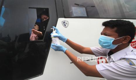 Petugas memberikan cairan antiseptik atau hand sanitizer kepada penumpang bus di terminal Pakupatan Serang, Banten, Rabu (18/3/2020). Hal tersebut dilakukan guna mencegah penyebaran COVID-19. (Antara//Weli Ayu Rejeki)