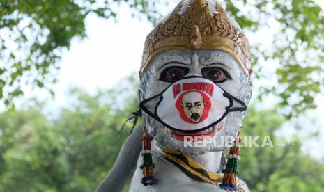 Patung wayang yang dipasangi masker kain di halaman Balai Kota Solo, Jawa Tengah, Ahad (19/4). Pemkot Solo memasang masker pada patung- patung wayang yang ada di wilayah Balai Kota Solo tersebut sebagai salah satu bentuk kampanye penggunaan masker bagi masyarakat guna mencegah penularan COVID-19