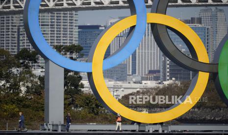  Pekerja berdiri di atas tongkang membawa monumen cincin Olimpiade di tepi laut Taman Laut Odaiba, di Tokyo, Jepang, 01 Desember 2020. Monumen cincin Olimpiade telah dipasang kembali ke lokasi aslinya setelah pekerjaan pemeliharaan. Olimpiade Tokyo 2020 telah dijadwalkan ulang menjadi 23 Juli 2021, karena pandemi virus corona.