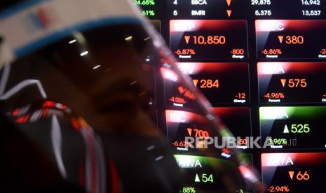 Petugas kebersihan beraktivitas di dekat layar pergerakan Indeks Harga Saham Gabungan (IHSG) di Bursa Efek Indonesia (BEI), Jakarta, Kamis (10/9). IHSG dibuka turun ke posisi 6.5078,58 dan terus melorot ke posisi 6.562,31. 