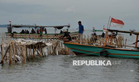 Personel TNI AL bersama warga membongkar pagar laut di Perairan Tanjung Pasir, Kabupaten Tangerang, Banten, Sabtu (18/1/2025).