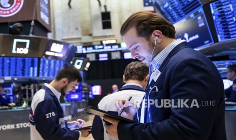  Dalam foto ini disediakan oleh New York Stock Exchange, pedagang Ben Tuchman, kanan, bekerja di lantai, Selasa, 15 Februari 2022. Perusahaan investasi AS PIMCO mengatakan fokus bank-bank sentral dalam memerangi inflasi yang terus-menerus tinggi dapat menyebabkan resesi selama dua tahun ke depan. 