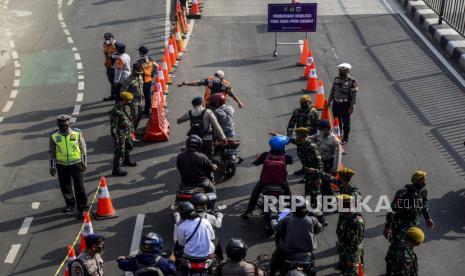 Petugas memeriksa surat tanda registrasi pekerja (STRP) atau surat tugas pengendara saat diberlakukan penyekatan di Jalan Raya Mampang Prapatan, Jakarta, Kamis (15/7). Ditlantas Polda Metro Jaya menambahkan lokasi penyekatan menjadi 100 titik di wilayah DKI Jakarta untuk mengurangi mobilitas warga selama masa PPKM darurat. Republika/Putra M. Akbar