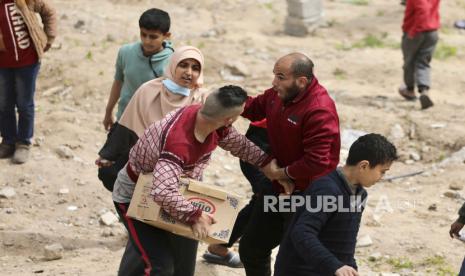 Warga Palestina bergegas mengumpulkan bantuan kemanusiaan yang dijatuhkan dari udara ke Kota Gaza, Jalur Gaza, pada Ahad, 17 Maret 2024.